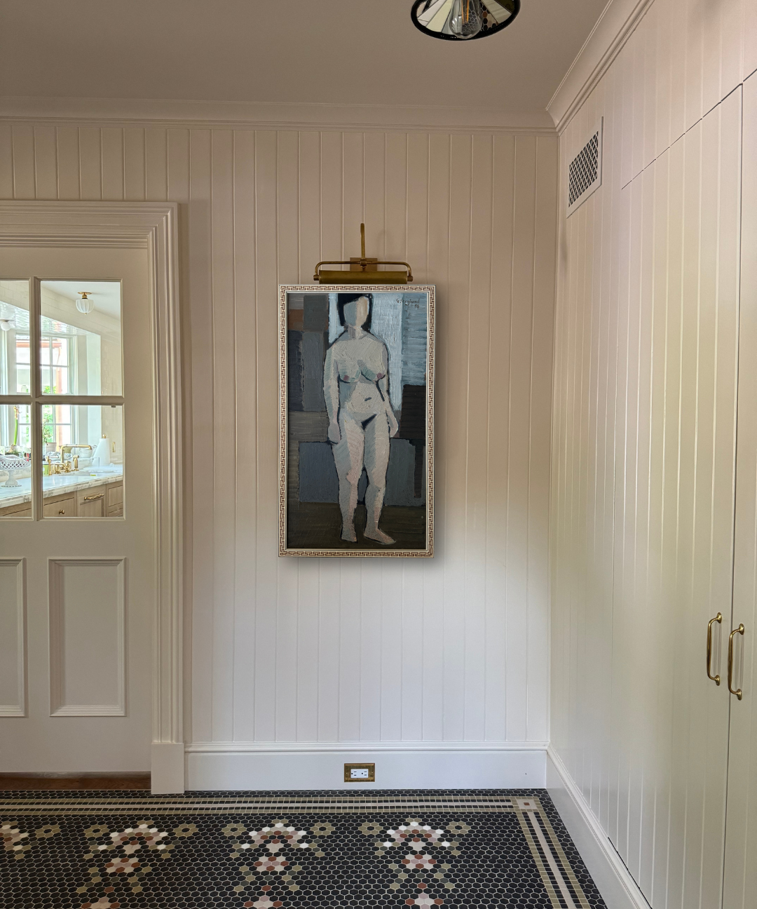 Framed artwork of a nude figure on a wall in a room with a tiled floor.